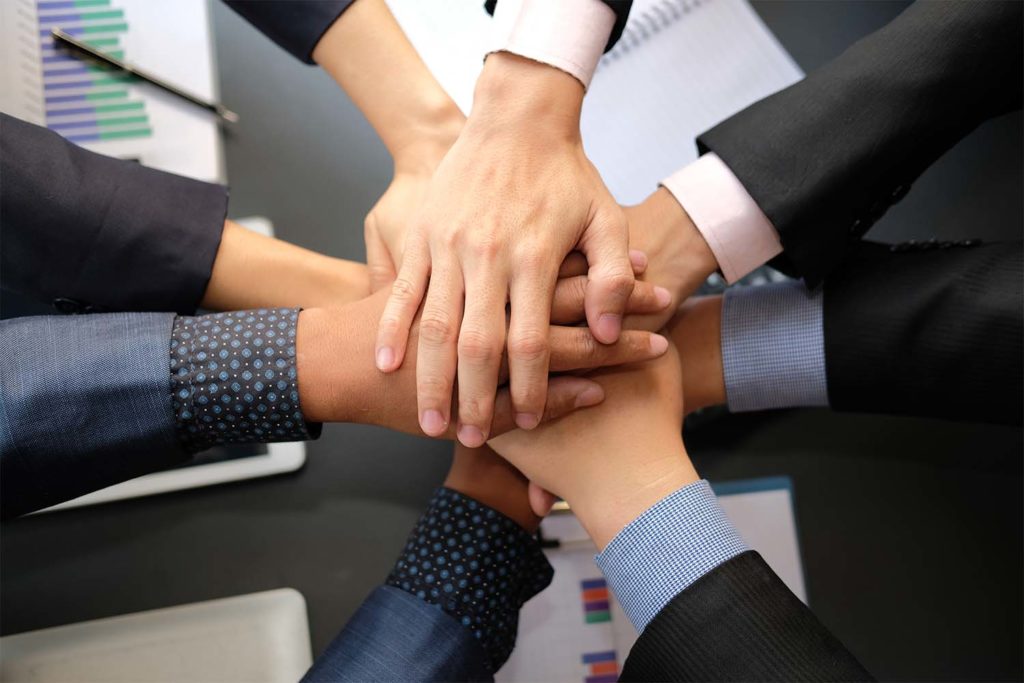 businessman joining united hand, business team touching hands together after complete a deal in meeting. unity teamwork partnership corporate concept