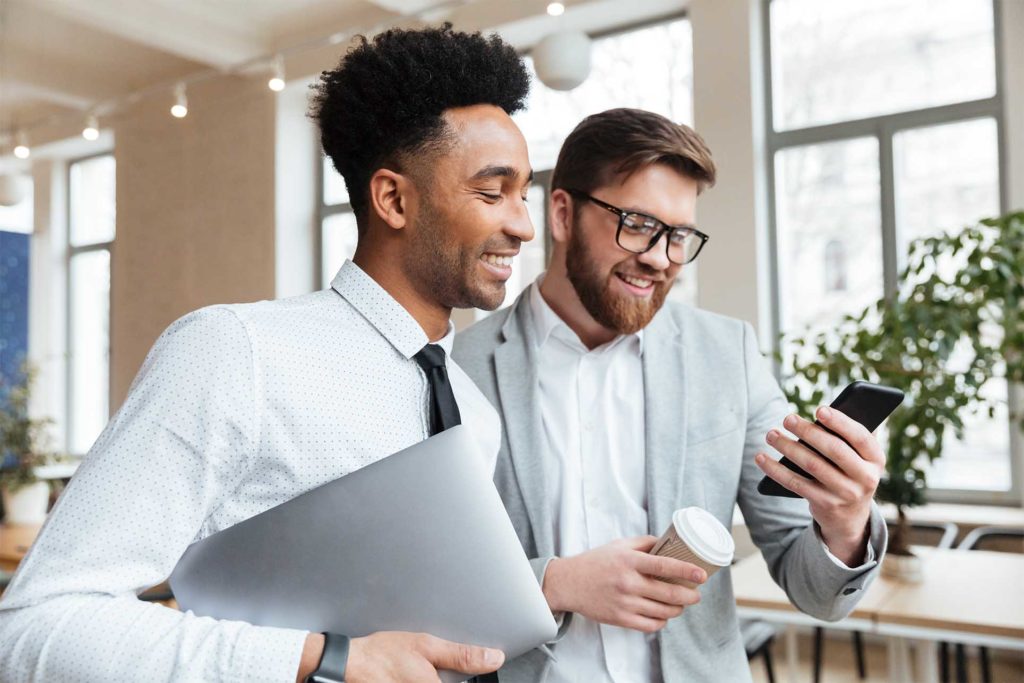 Image of happy businessmen colleagues talking with each other using mobile phone