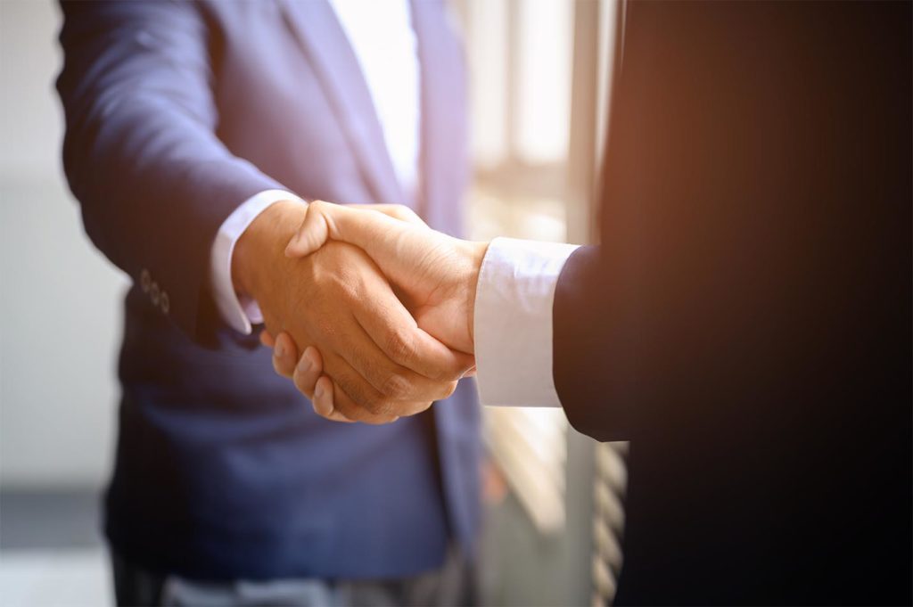 Two businessmen join hands for business cooperation