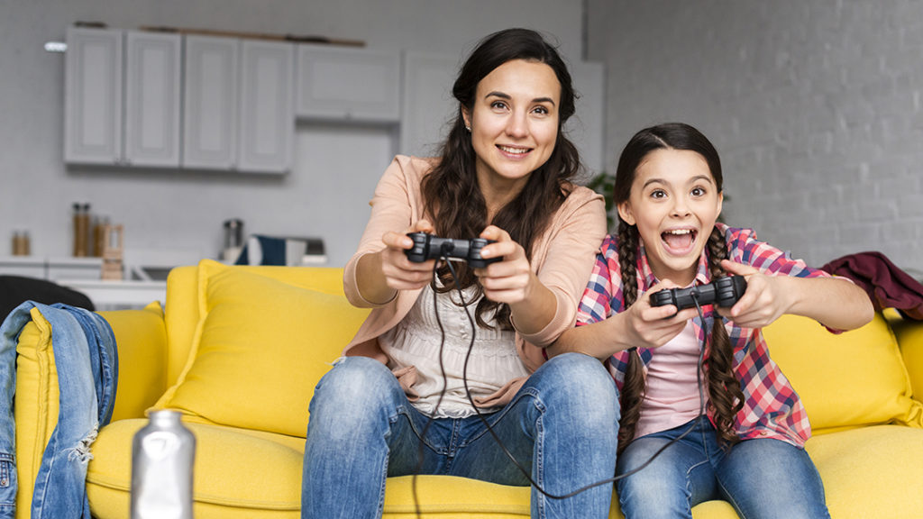 The woman and the girl are playing on the console